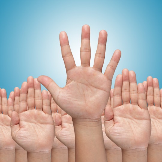 Many Hands raise high up on blue background